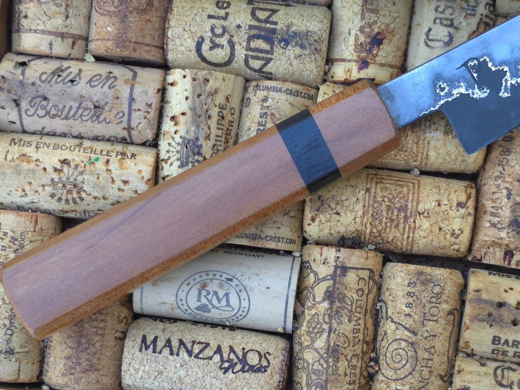 Wooden saya and spacer detail over vintage wine corks